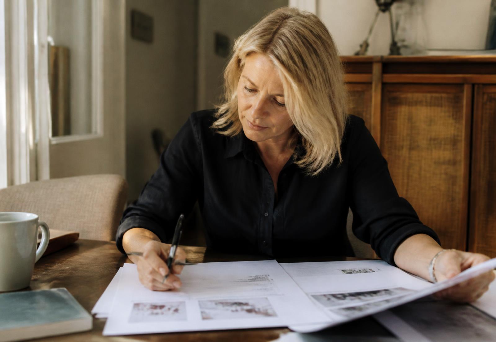 An experienced independent expert working through printed business decisions at home
